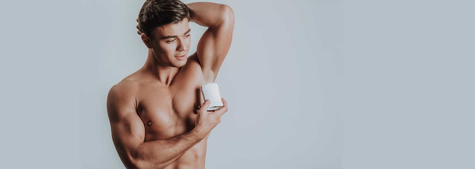 A guy applying deodorant