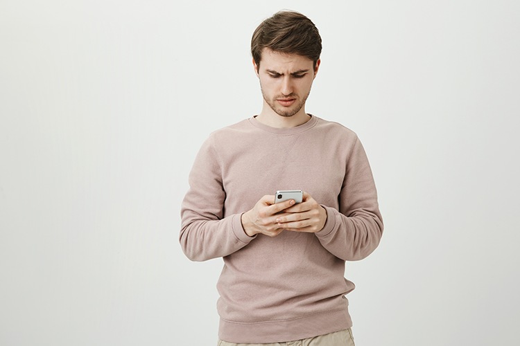 Young man discouraged by reading a text message